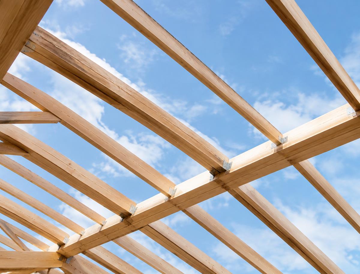 Neue Dachkonstruktion aus Holz mit Sparren und Pfetten gegen den Himmel
